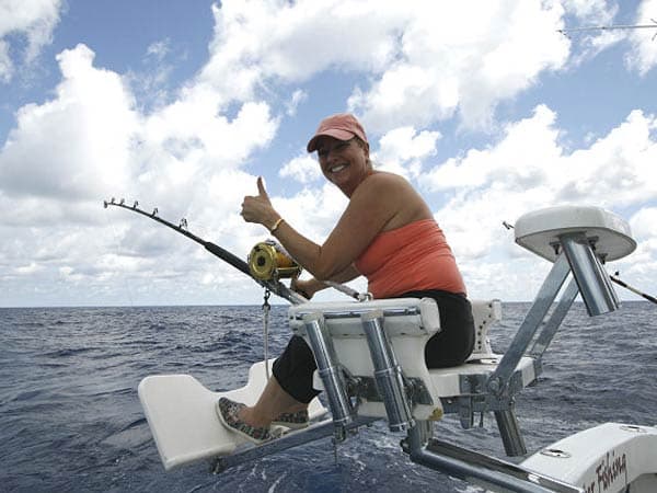 Angler battling a big fish from the fighting chair aboard Mark The Shark